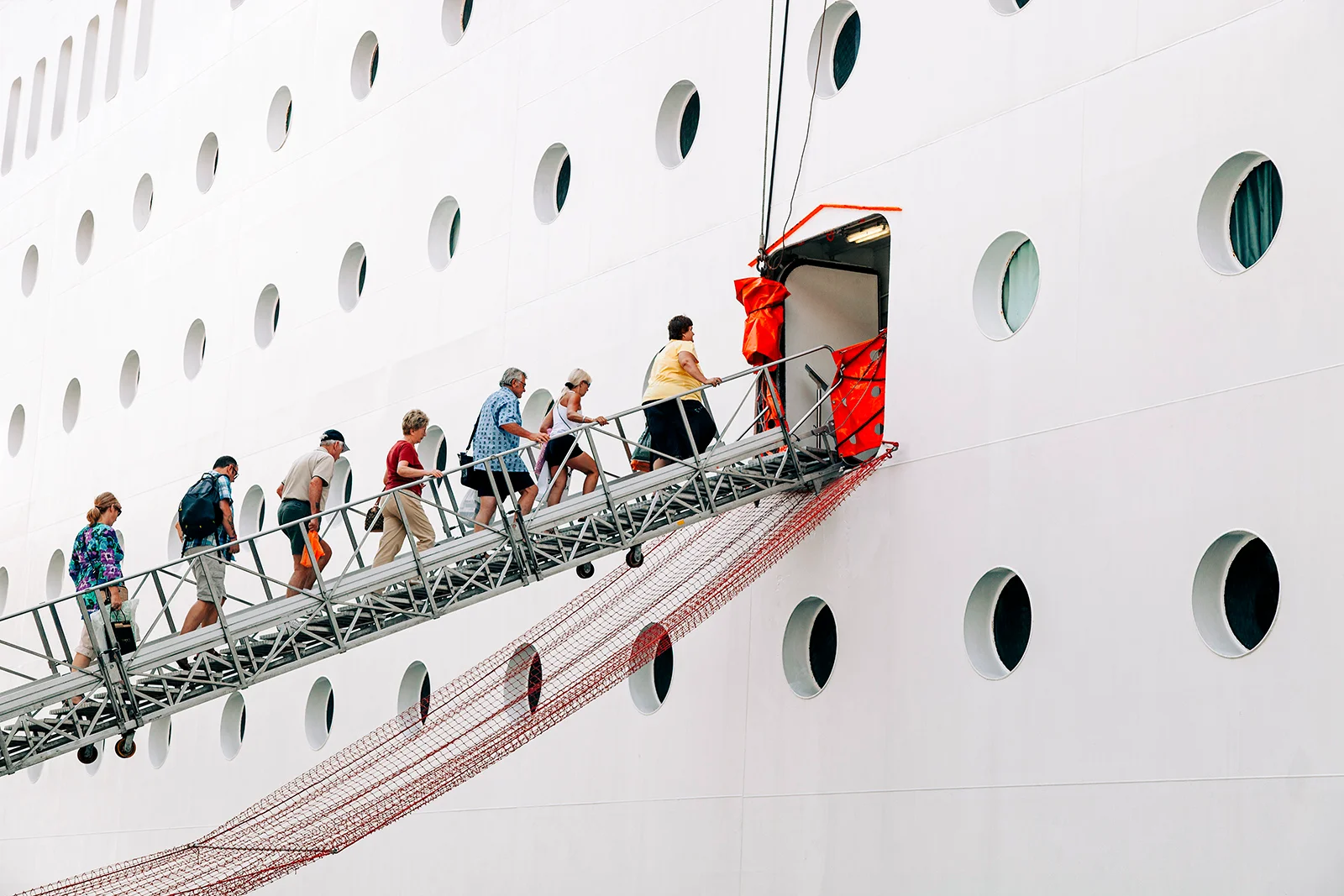 imagem com pessoas na passarela indo ate o navio de cruzeiro gangway